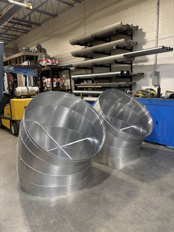 Spiral duct elbows with curved seams